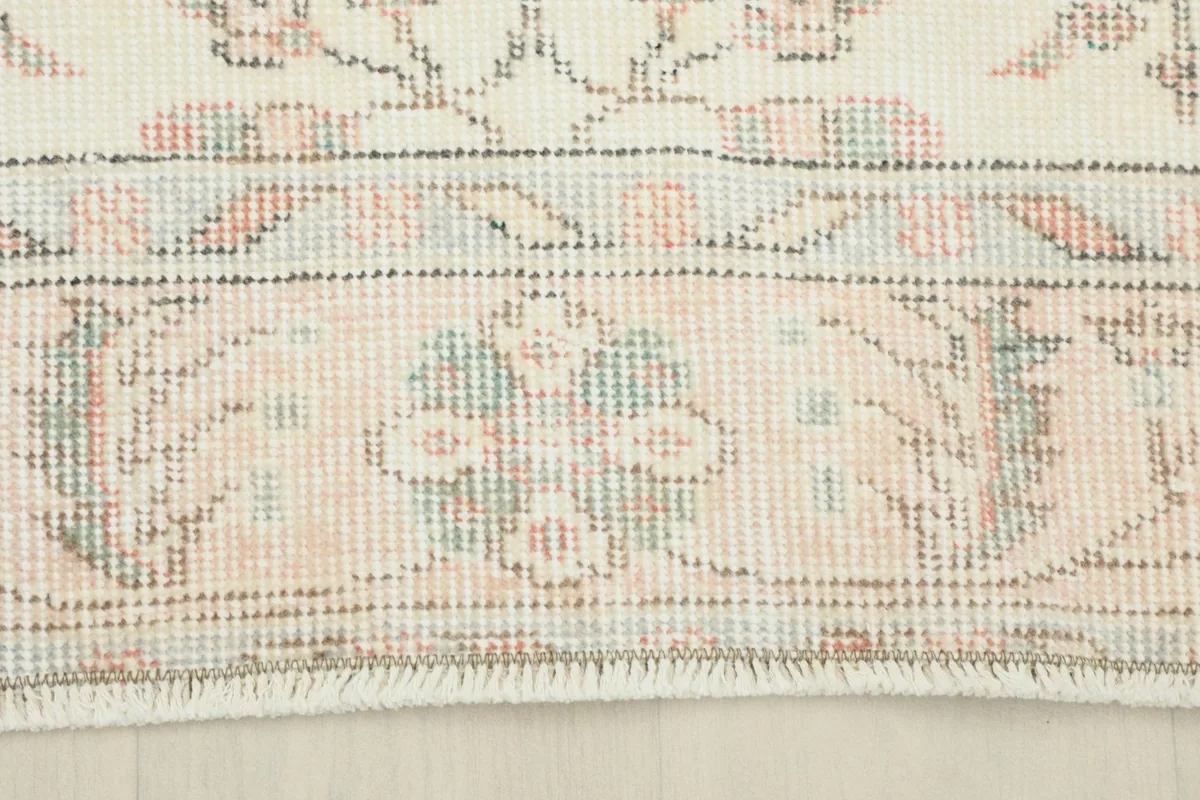 Close-up of the rug's border, showcasing its detailed patterns and soft color variations