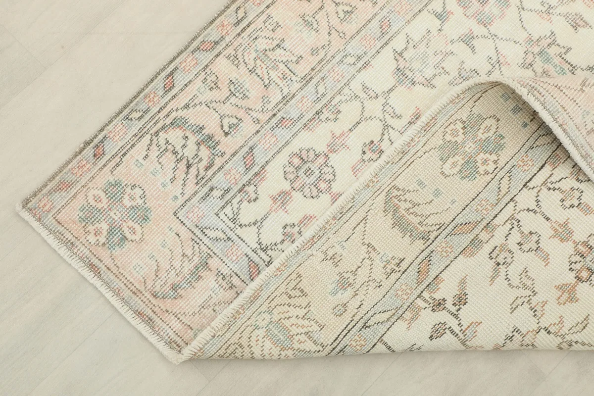 View of the rug folded back to reveal the cotton foundation and reverse side of the knots