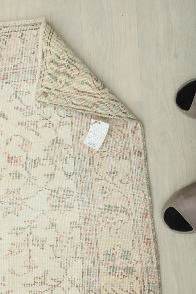 Overhead view of a corner of the rug with a tag, showing the natural fringe
