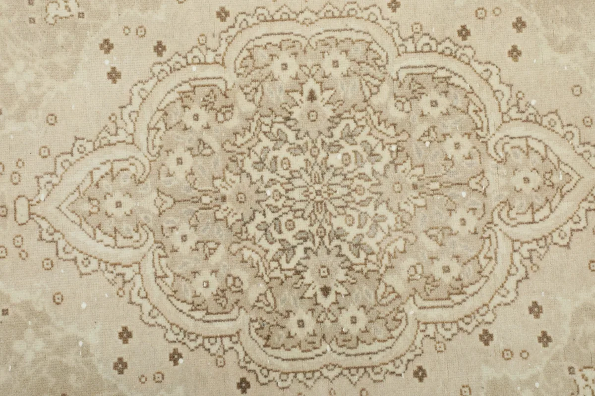 Close-up of the intricate floral patterns within the medallion of the vintage rug