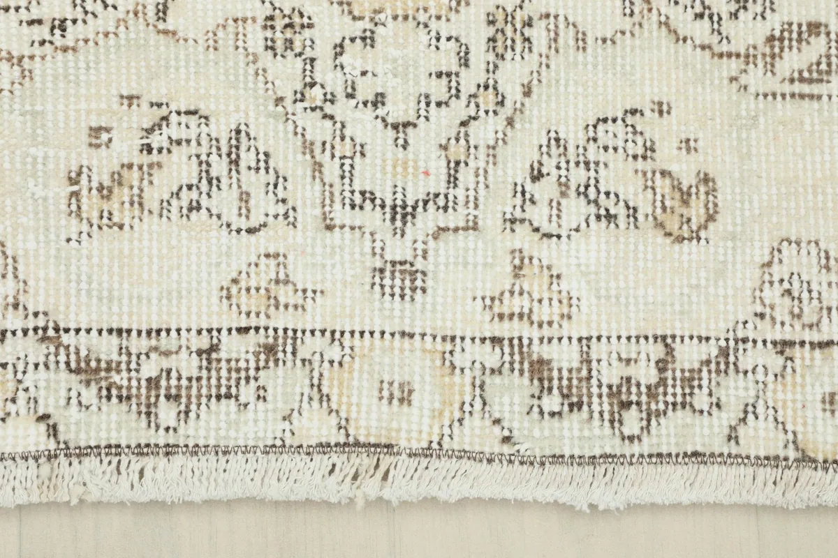 Close-up of the short, natural fringes and the distinct border pattern of the rug