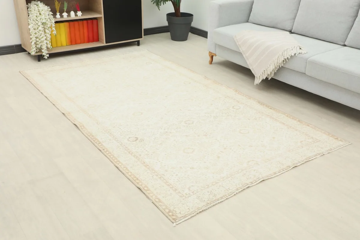 Angle view of the cream Anatolian rug in a living space, highlighting its placement relative to furniture.