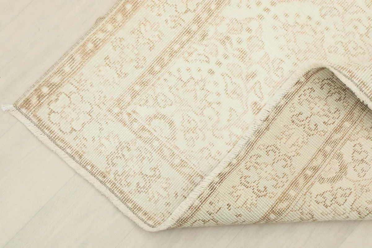 Corner of the rug folded back, showcasing the reverse side and the quality of the hand-knotting.