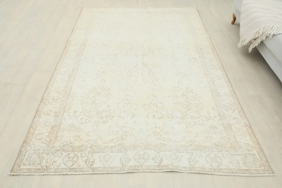 Full overhead view of the 5'3" x 8'6" ivory floral rug in a room, showing its overall appearance