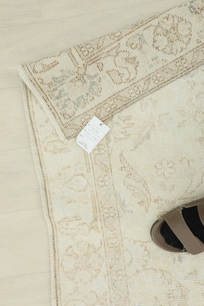 Overhead shot showing the rug with a size tag and a shoe for scale, emphasizing its medium size