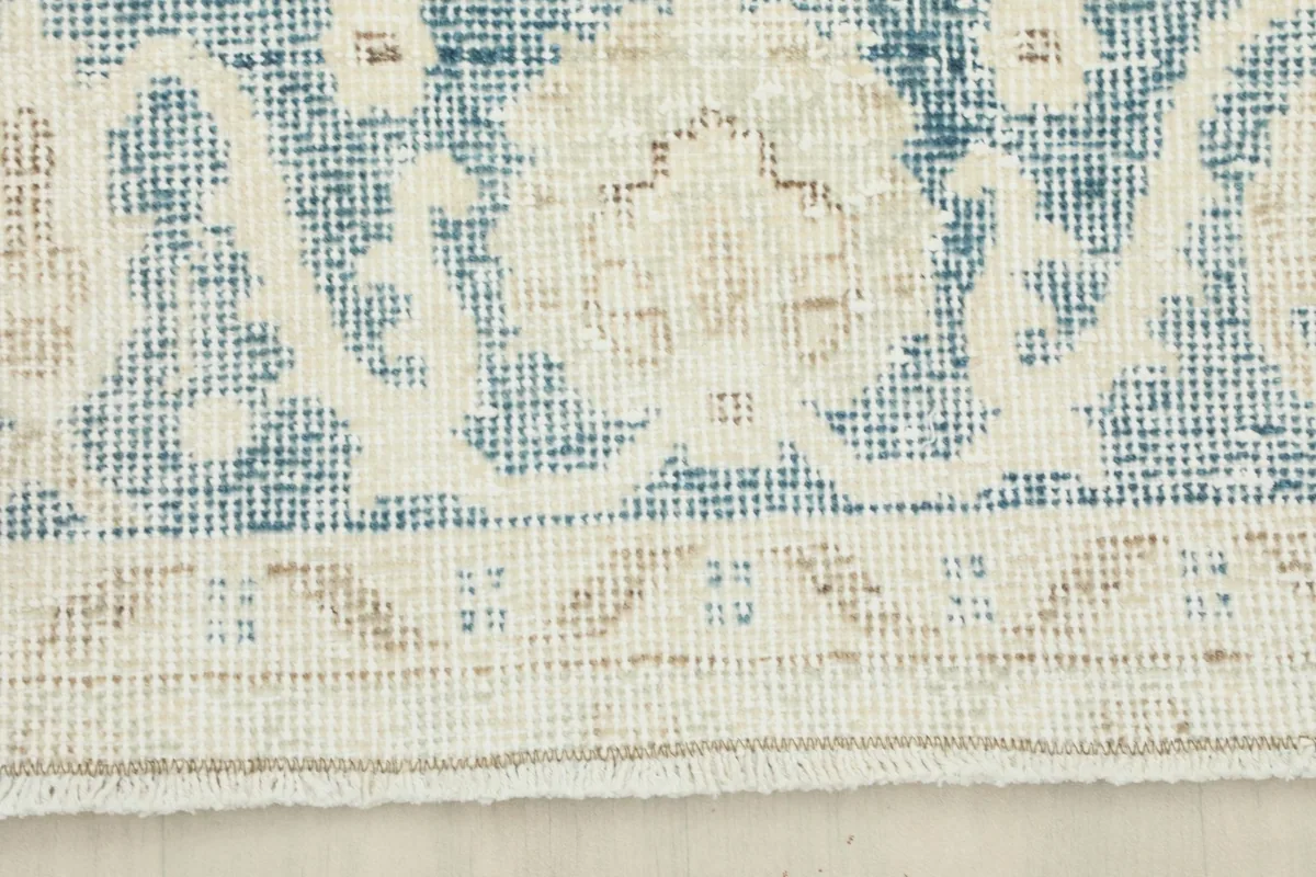 Detailed view of the intricate border design and the edge finishing of the rug.