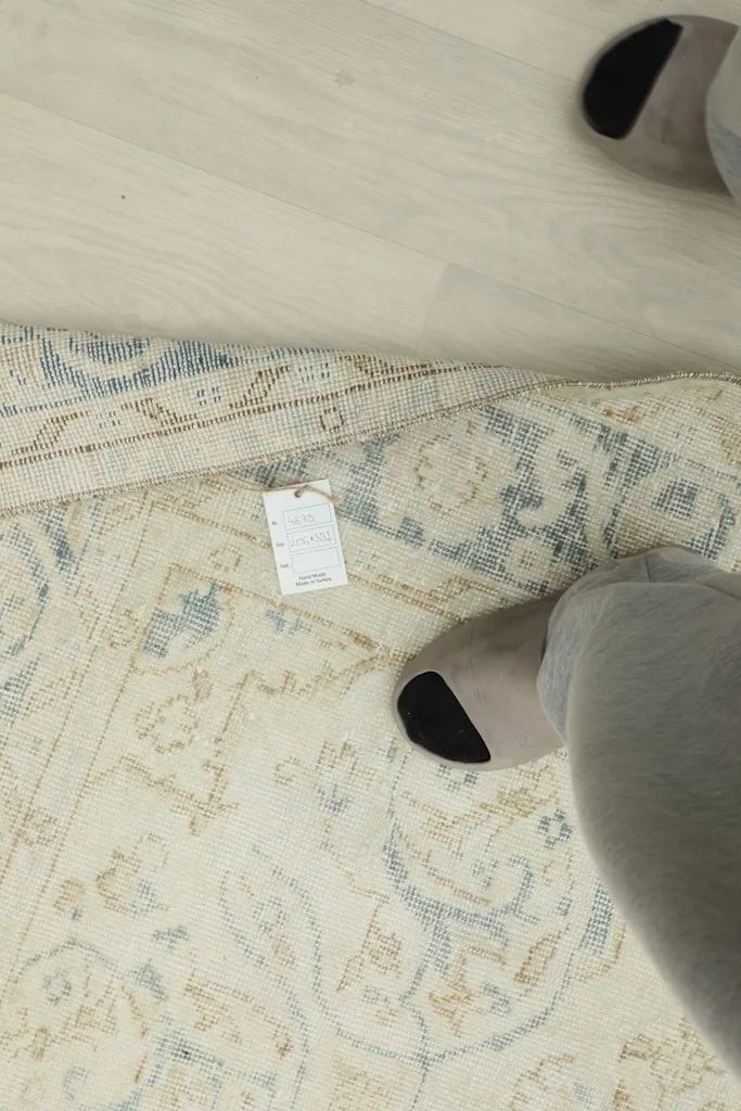 Close-up of the rug's reverse side with a tag, showing the hand-knotted construction.