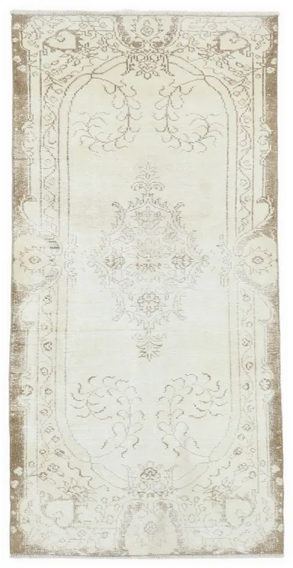 Full overhead view of the ivory and brown vintage Anatolian area rug with a central medallion.