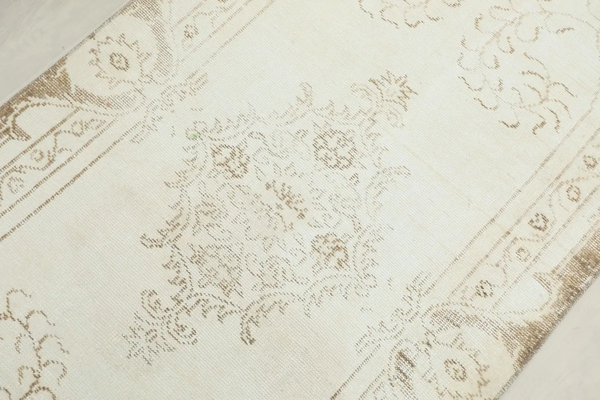 Detailed view of the central medallion motif and surrounding patterns on the ivory field.