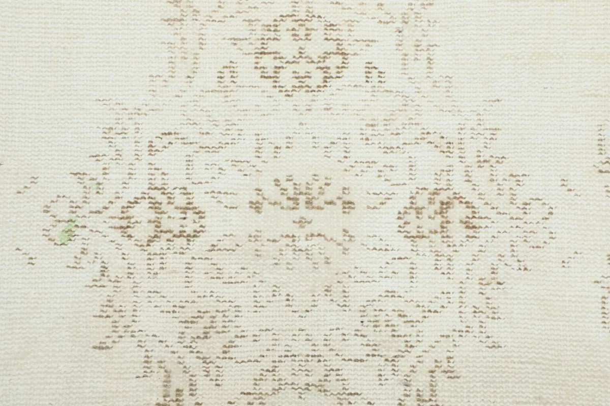 Macro shot of the low wool pile and the intricate knotting of the medallion design.