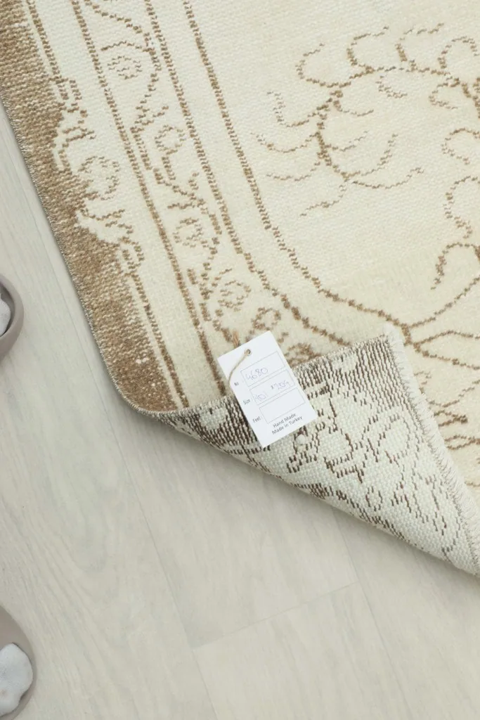 View of the rug with the product tag attached, showing the back and a glimpse of the design.