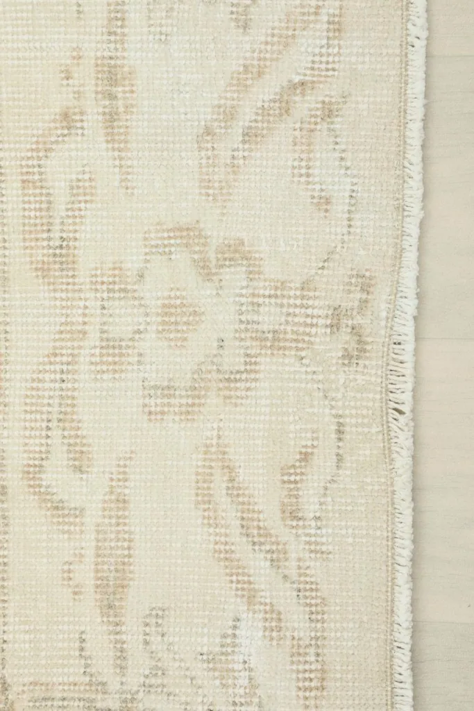 Detail of the rug's edge, showing the short fringe and the tightly woven wool pile