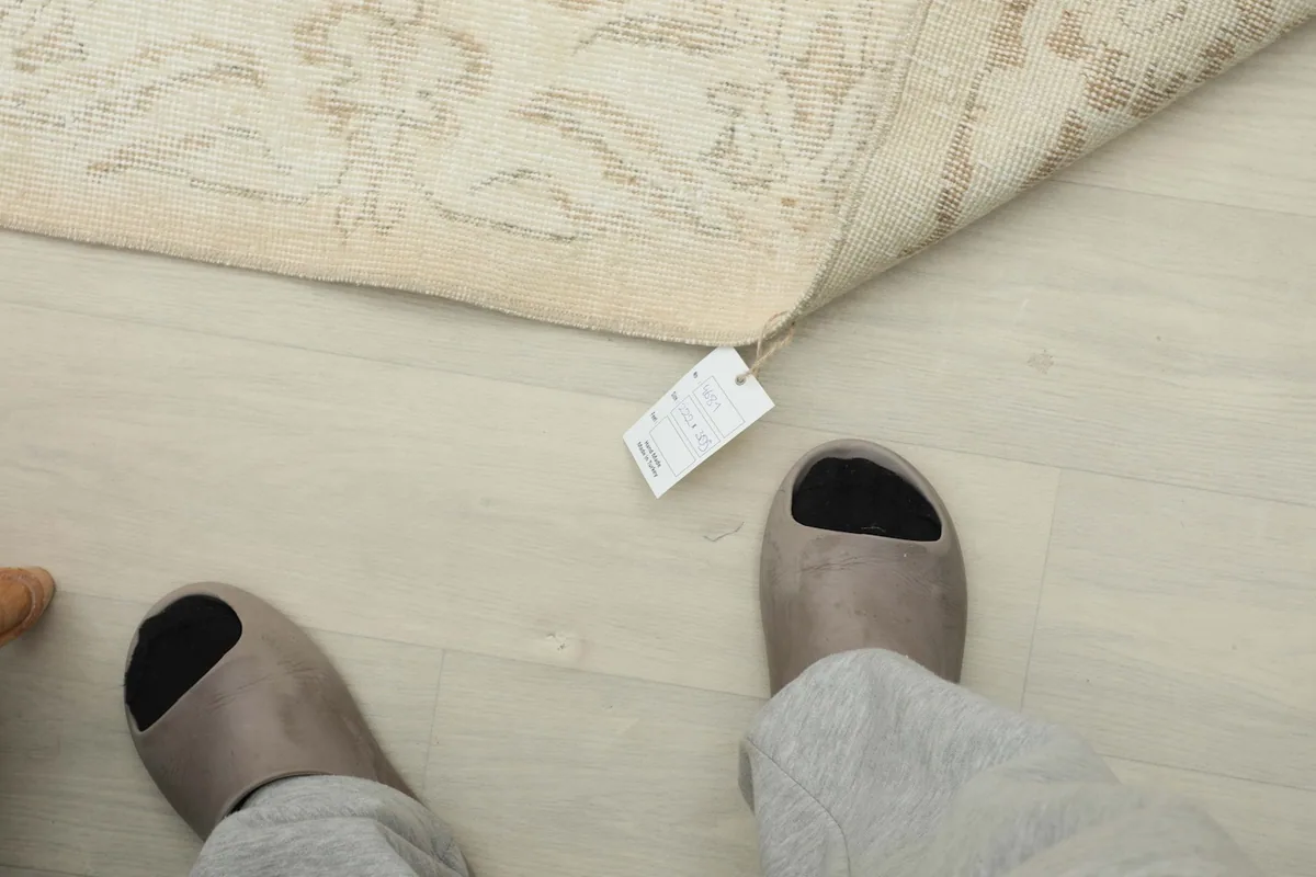 View from above feet, showing the rug's tag and a sense of its texture on the floor