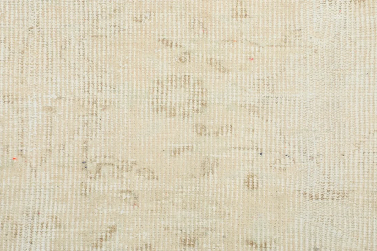 Close-up of the low wool pile and underlying cotton foundation, showcasing the rug's construction.