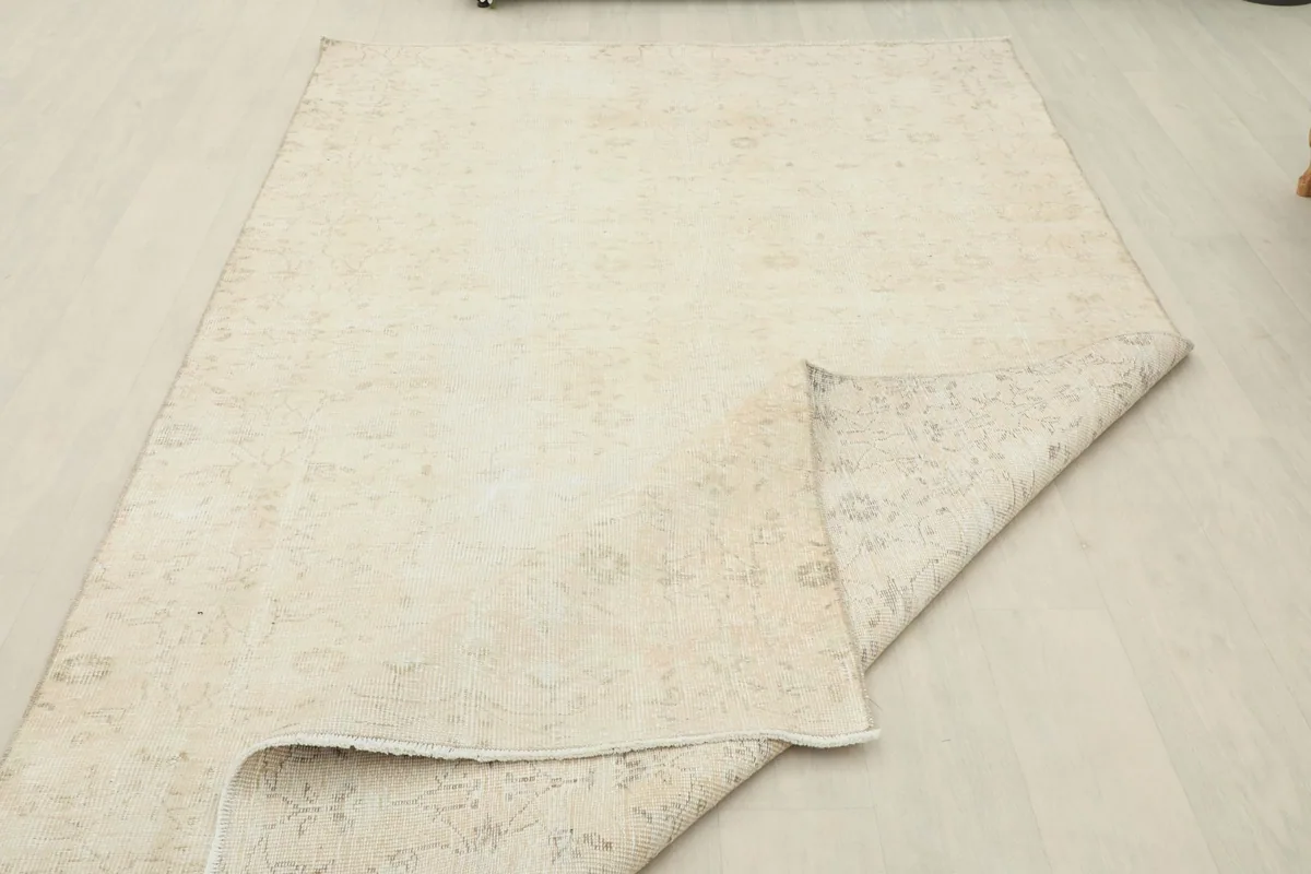 View of the rug partially folded, showing the back of the rug and the consistent knotting.