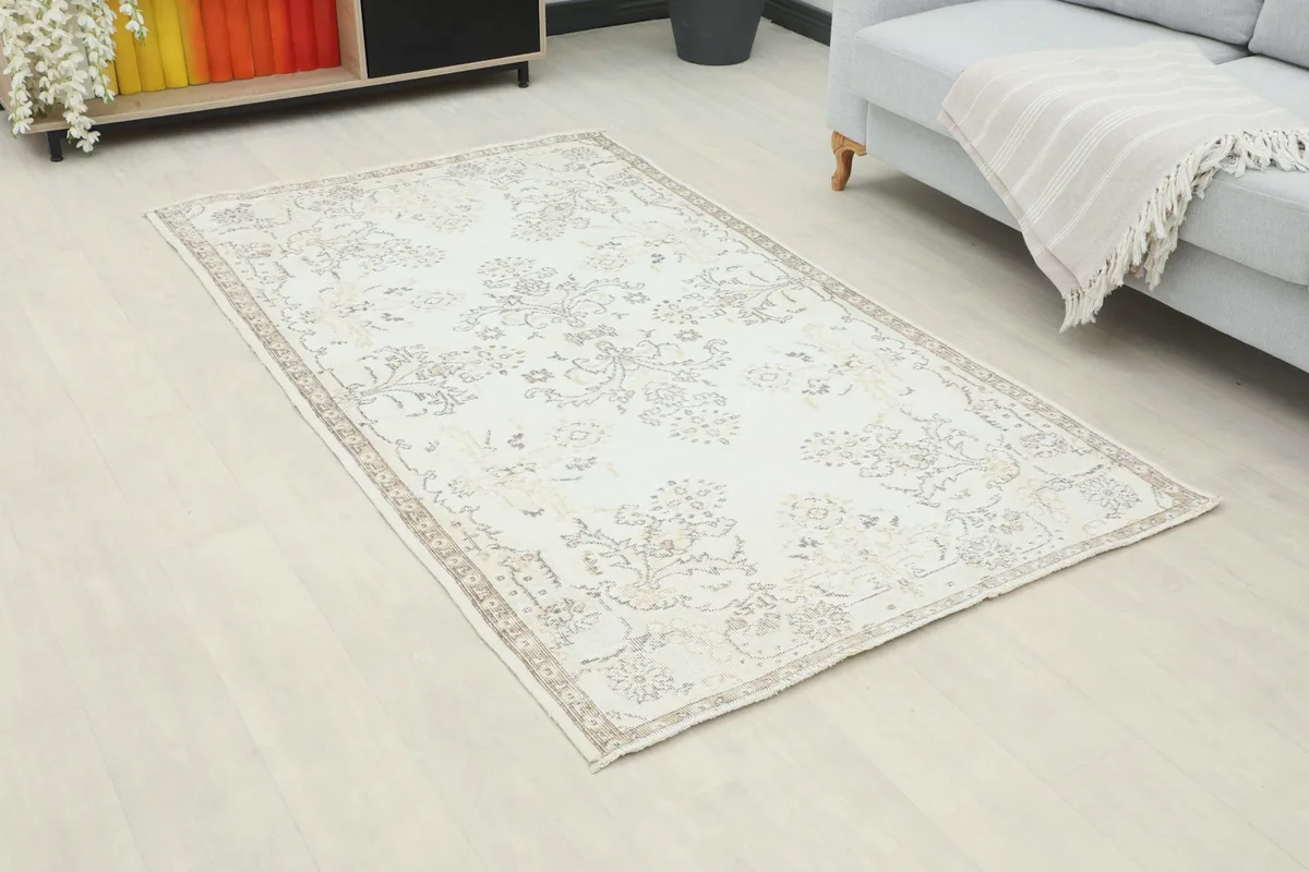 Angle view of the ivory floral rug on a light floor in a modern living space