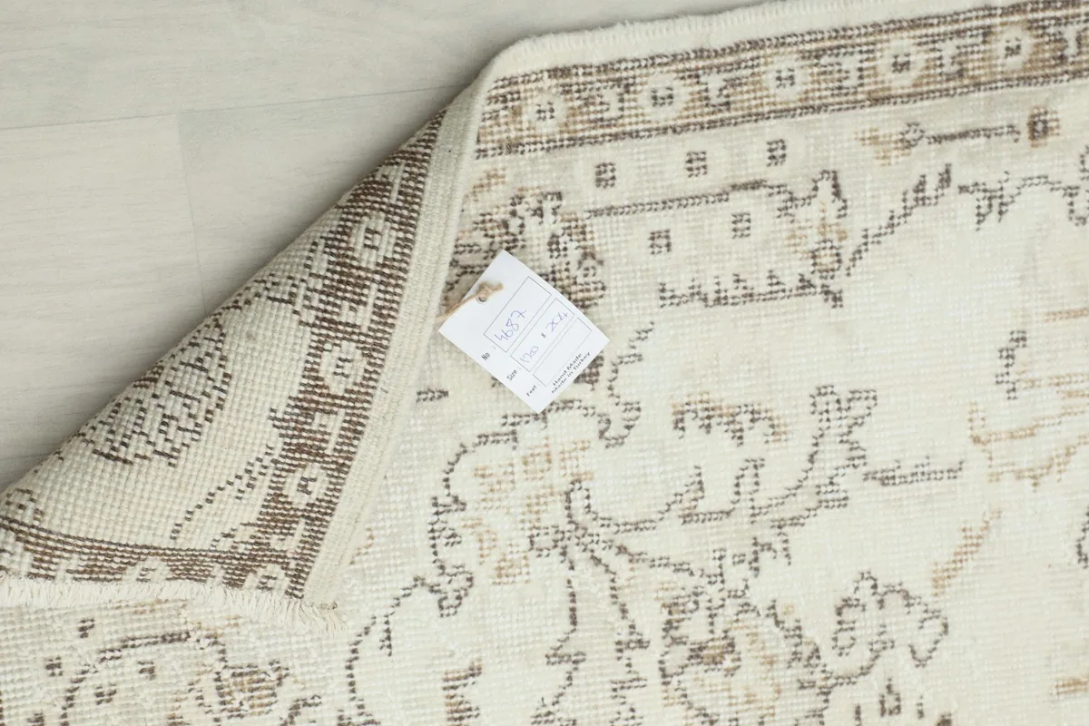 Reverse side of the hand-knotted wool rug, showing the cotton foundation and knotting