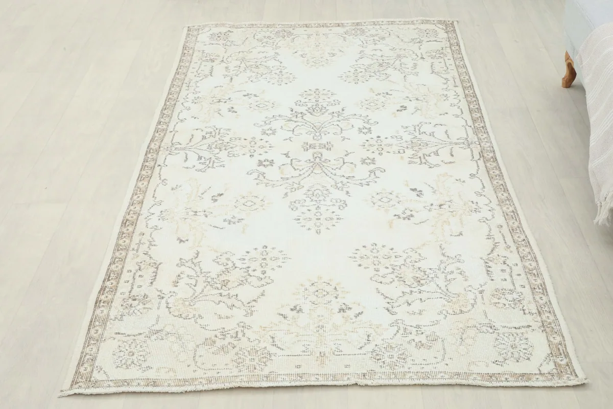 Full overhead view of the ivory floral medallion rug placed on a light floor