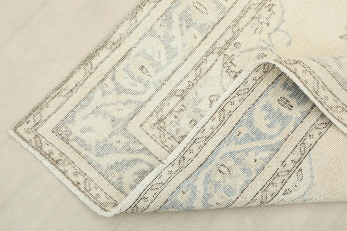Corner of the rug folded to show the hand-knotted cotton foundation and reverse side