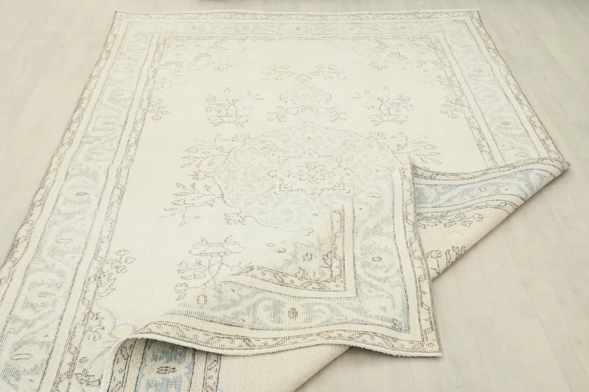 Rug partially folded, revealing the underside and the overall distressed appearance