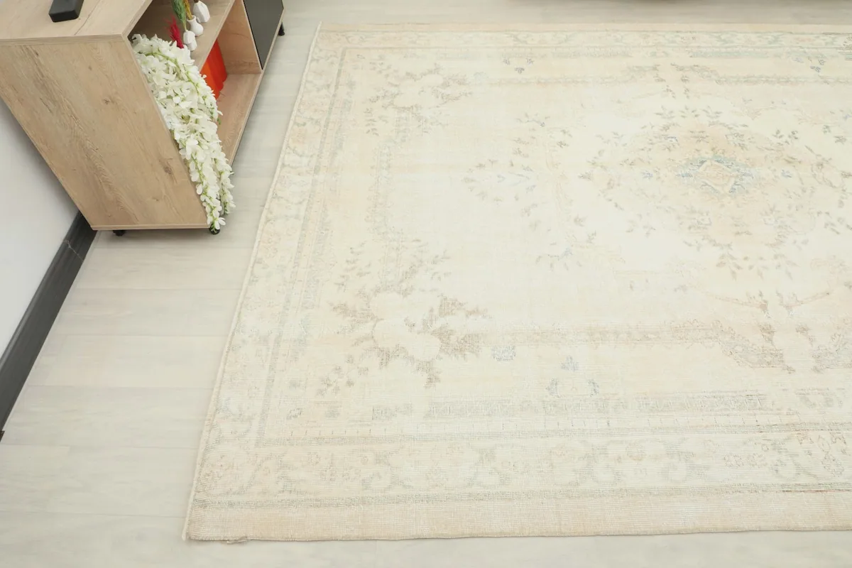 Overhead angle capturing the subtle patterns and muted tones of the vintage rug