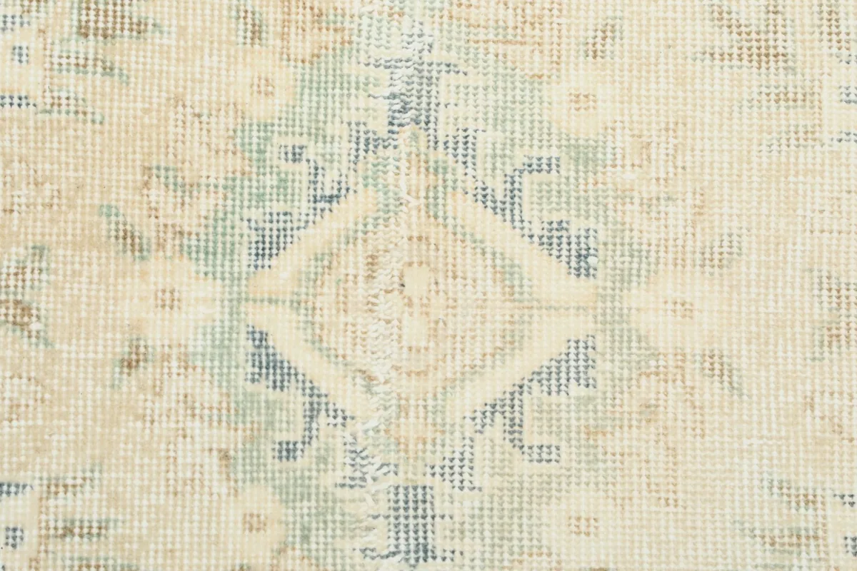 Close-up of the faded gray and blue details within the rug's pattern