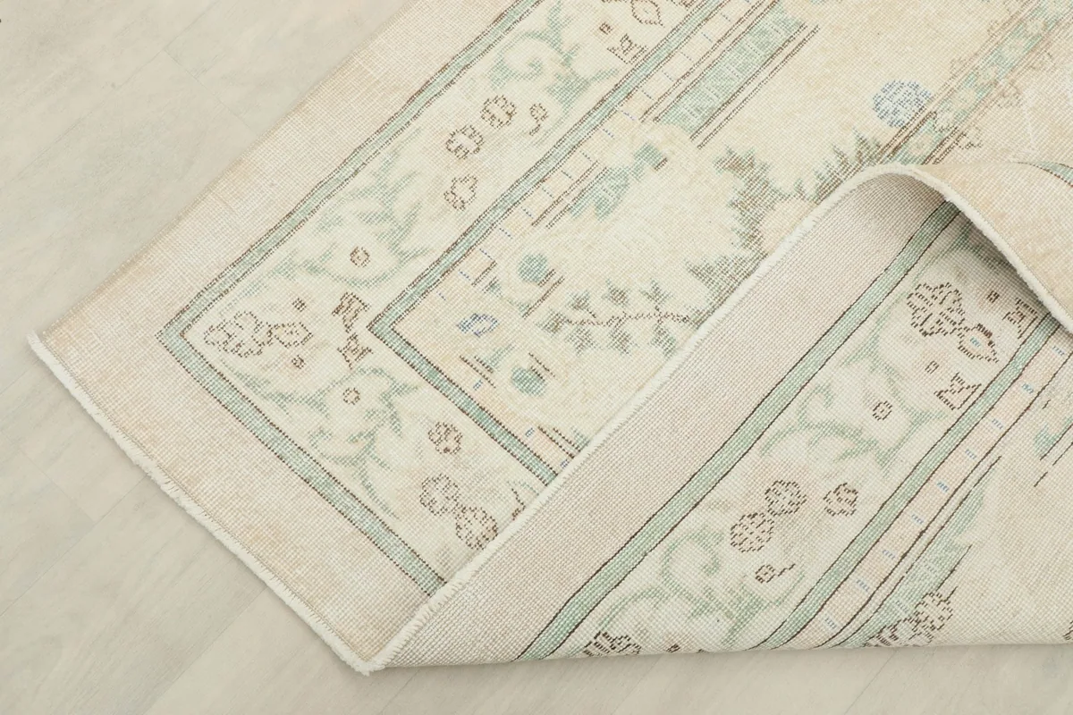 Corner of the rug folded back, revealing the reverse side and construction