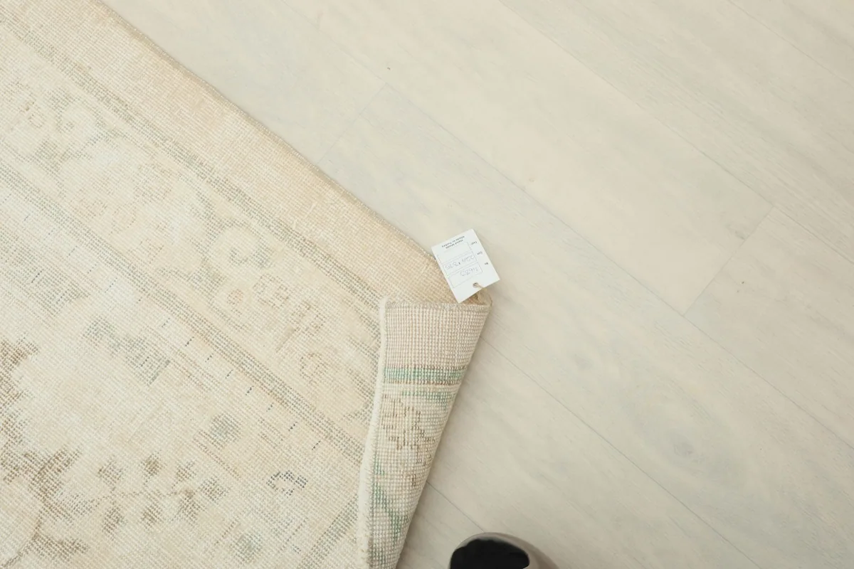 Overhead view of the rug's corner with a tag, showing the natural fringe