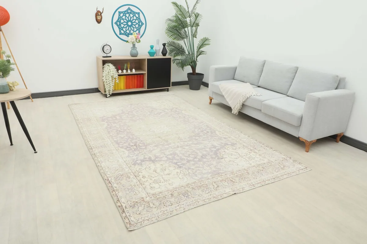 Vintage Anatolian rug in a modern living room setting with a light gray sofa and wooden furniture.