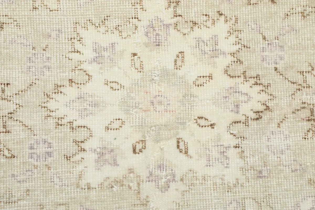 Close-up of the low pile and hand-knotted texture of the vintage wool rug, showing minor wear.