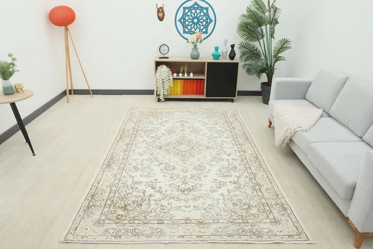 Full room view showcasing the ivory and beige vintage rug as a focal point in a brightly lit living area.