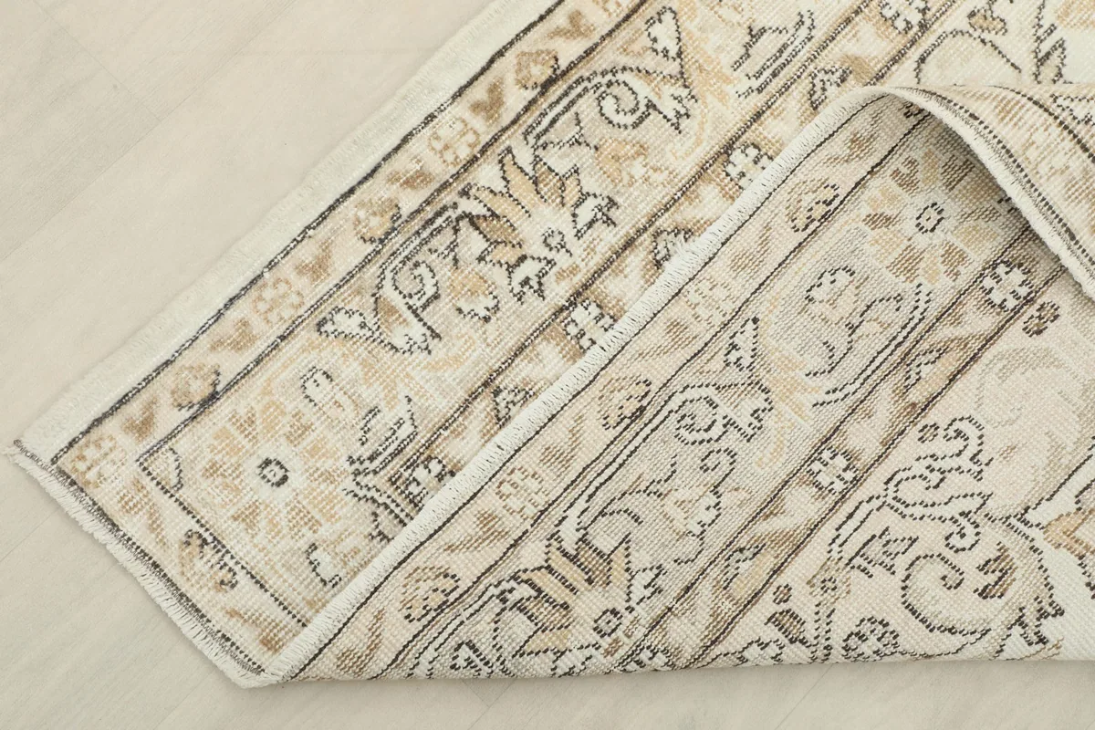 View of the rug's underside, revealing the hand-knotted cotton foundation and wool pile construction.