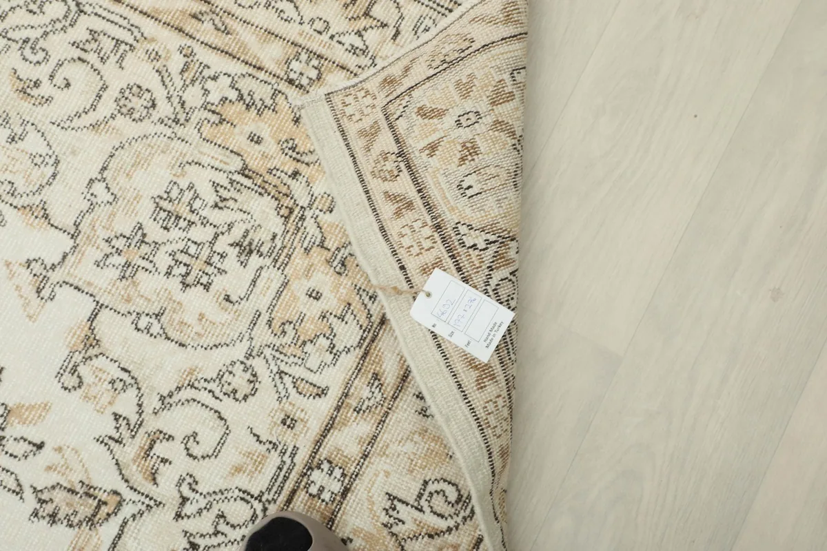 Close-up of the rug's corner with the product tag, showing the quality and origin information.