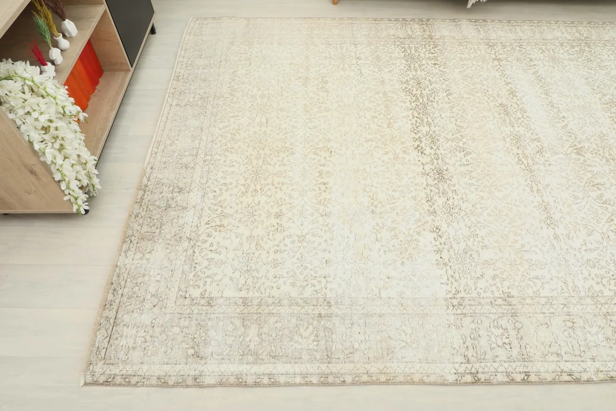 View from another angle highlighting the distressed texture and tan border details of the rug