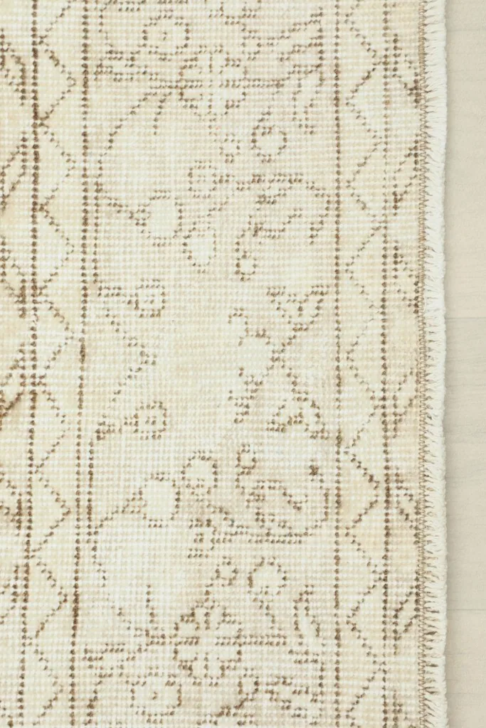 Detail of the rug's border design and the finished edge with minimal fringe