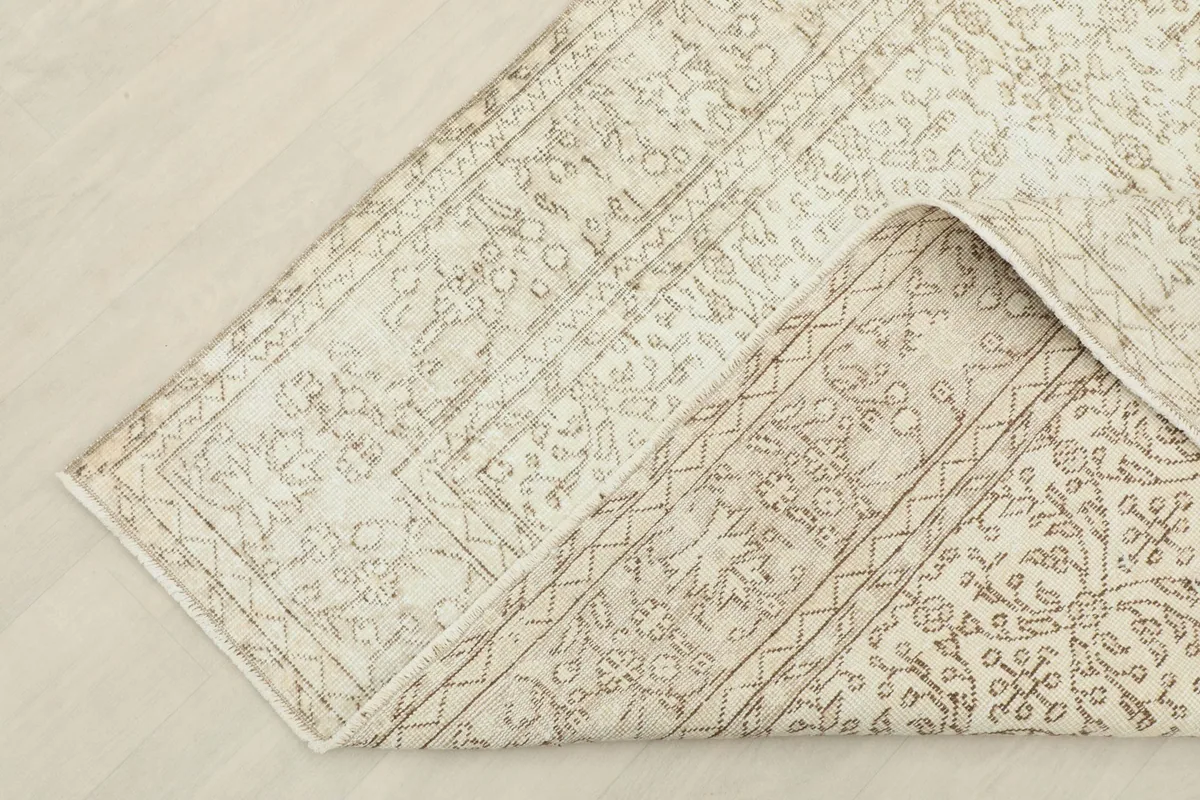 Corner of the rug folded back to show the cotton foundation and reverse side of the knots