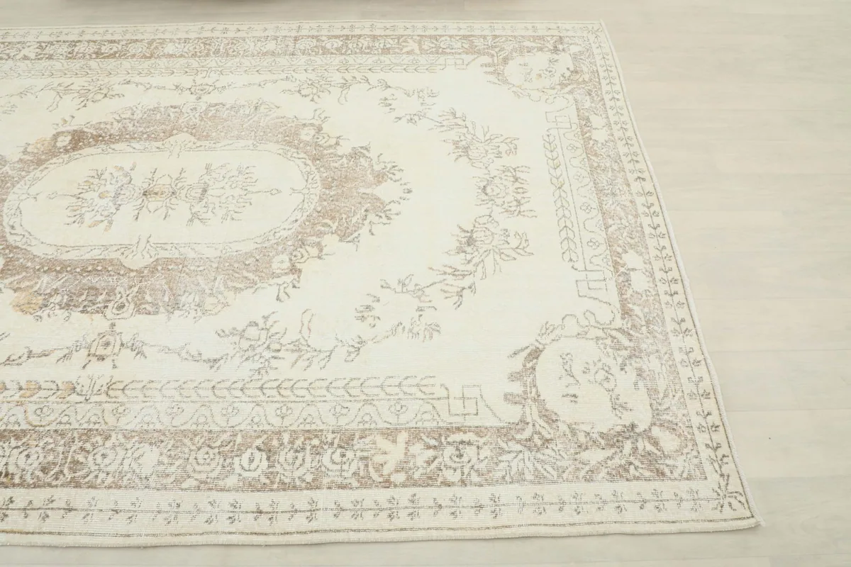 Corner view of the vintage rug, highlighting the border design and overall coloration.