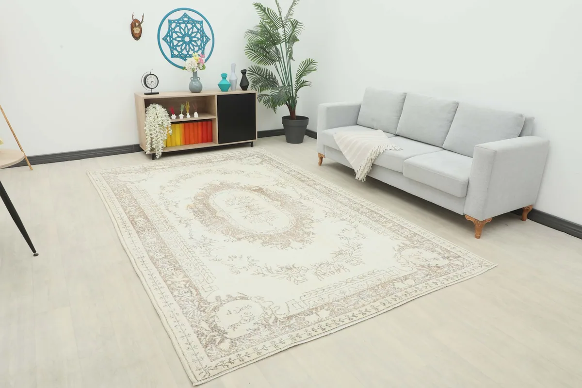 The 7x11 vintage rug laid out in a living room with a gray sofa and modern decor.