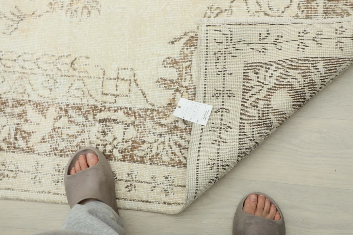 View of the rug's back with a tag, demonstrating the hand-knotted quality.