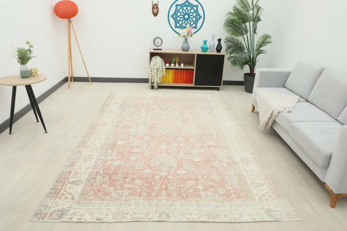 Wide shot of the rose and cream vintage rug anchoring a cozy living room space with contemporary furniture.