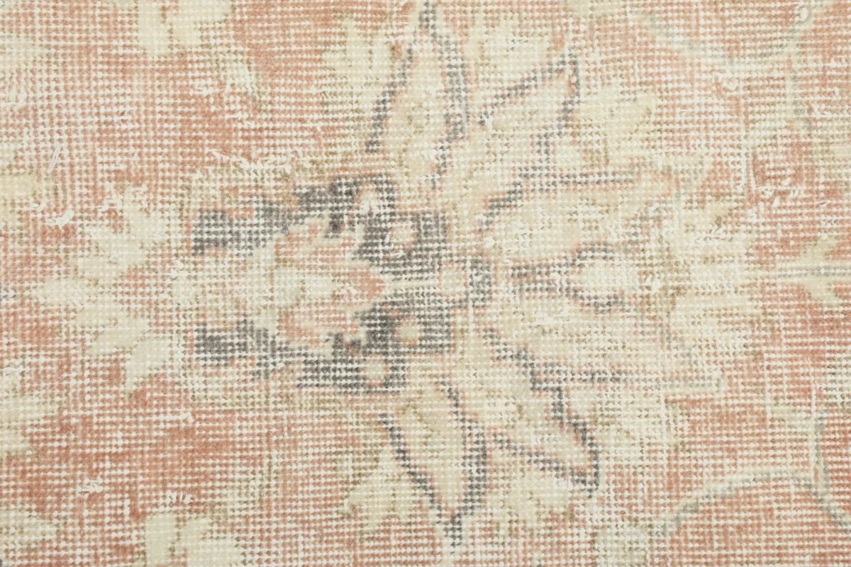 Macro view of a central floral motif, revealing the individual wool knots and subtle color shifts.