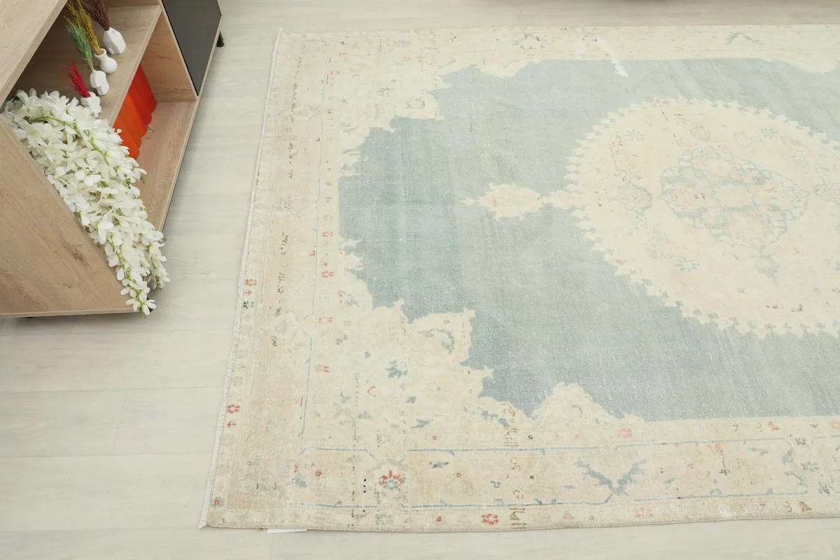 Angled view showing the cream border and a corner of the blue field, with subtle motifs.