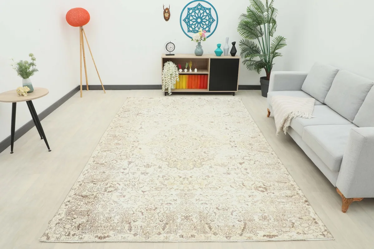 Overhead room view of the ivory and beige vintage rug, showing its placement in a spacious room.