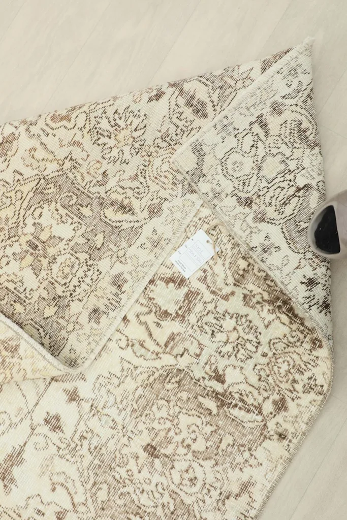 View of the back of the rug, revealing the hand-knotted structure and foundation.