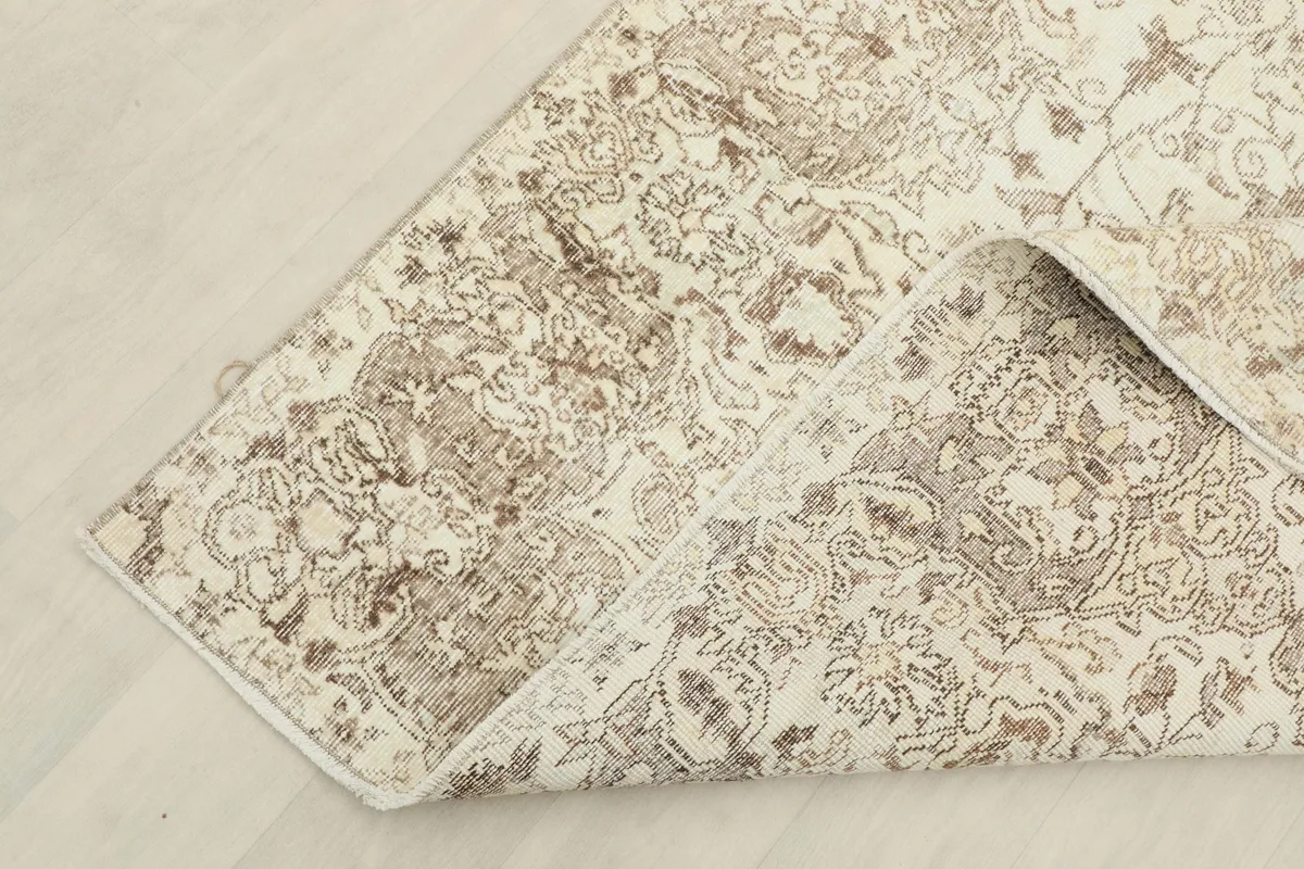 Corner of the rug folded to show the wool pile and cotton foundation construction.