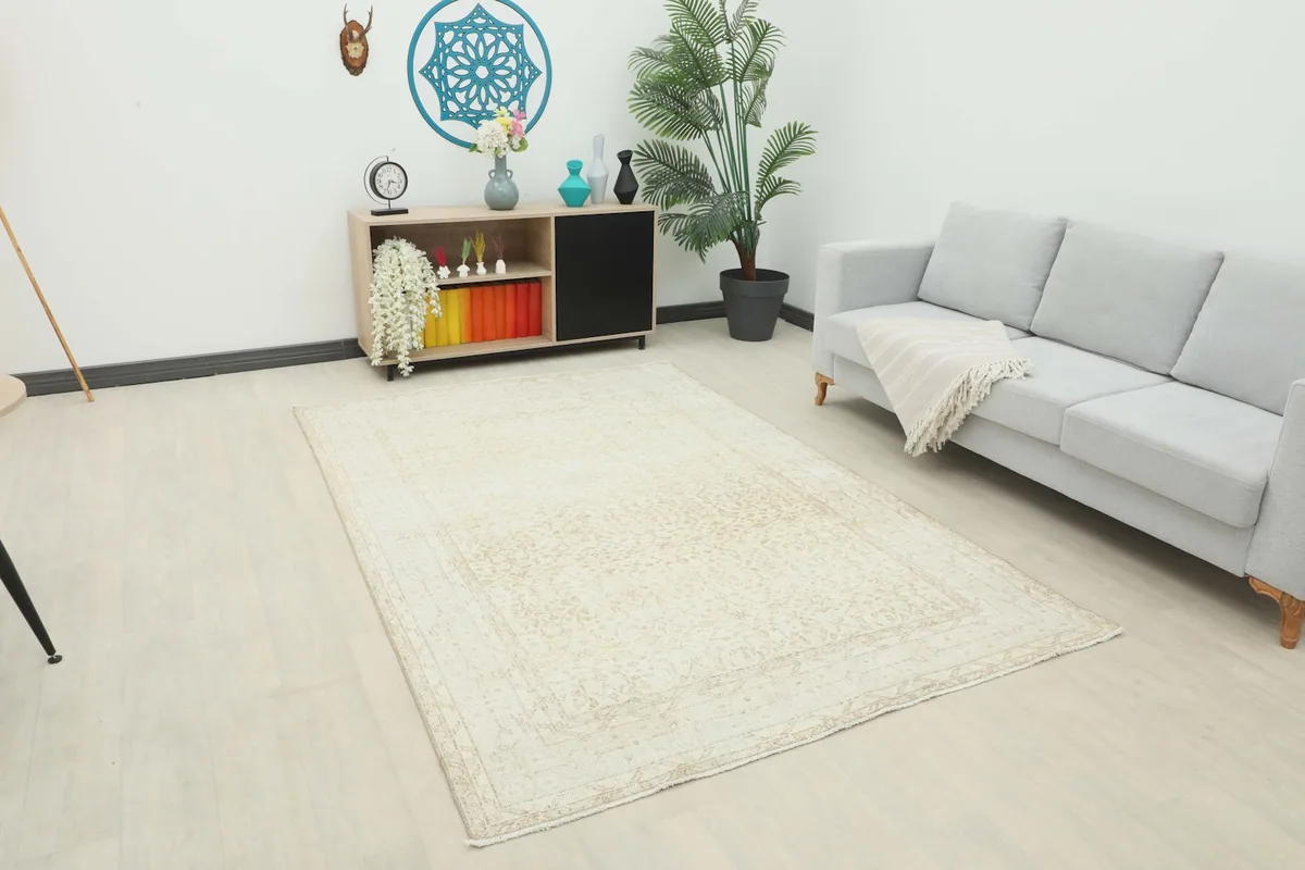 Cream and tan vintage rug placed in a modern living room setting