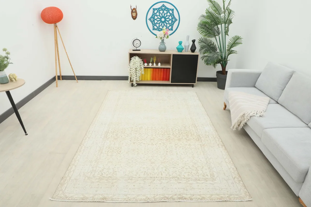 Full view of the cream and tan rug in a bright room with a sofa and decor