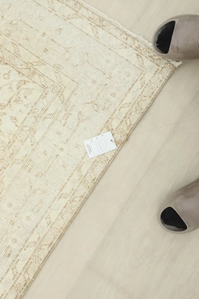 Overhead view showing the rug's label and scale next to feet