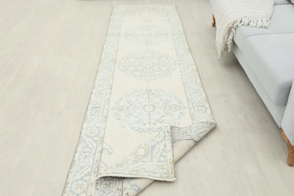 Long view of the vintage runner in a room, partially folded to show its flexibility and length.