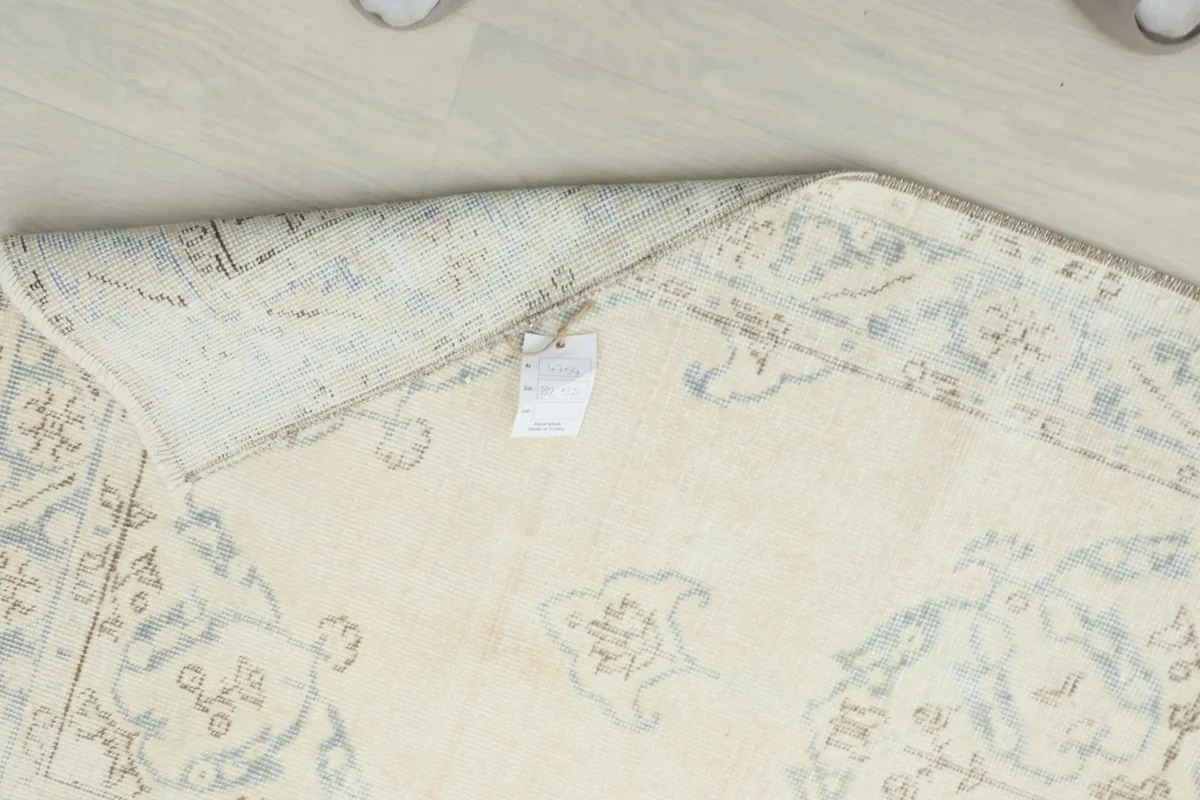 Underside of the rug, showing the cotton foundation and a product tag.